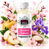 A bottle of Fizzy Whiz 'Ancient Sakura' fragrance oil centered against a white background, surrounded by decorative floral and fruit props including pink blossoms, a pear, an iris flower, and a bowl of rice. The bottle label is white with a pink block and black text.