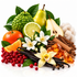 A styled botanical arrangement of natural ingredients on a white background, including a green bumpy fruit, yellow pears, an orange, sliced lime, white flowers, vanilla beans, red berries, cinnamon sticks, and honeycomb.