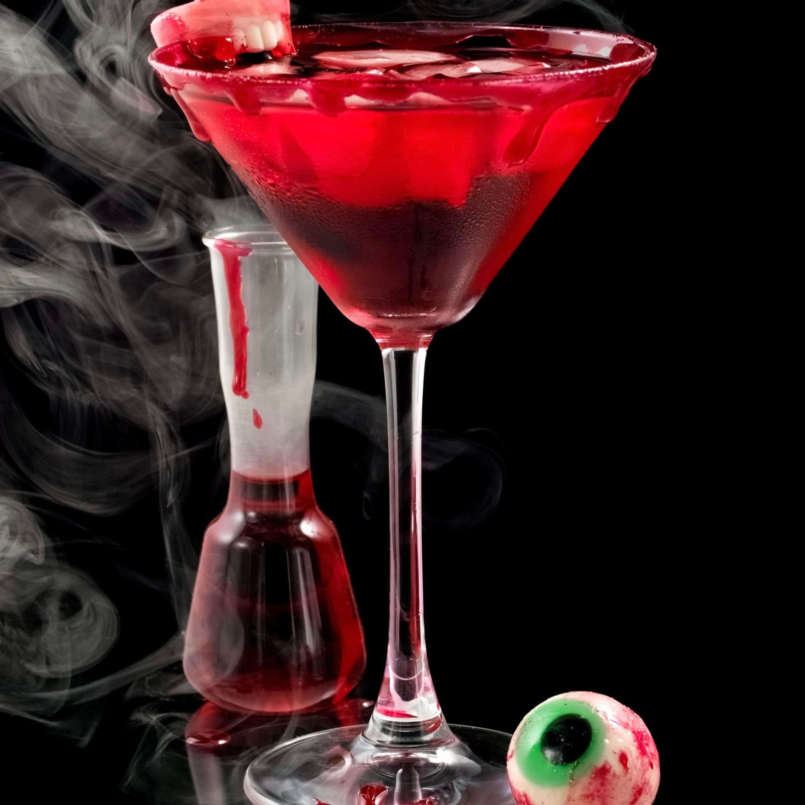 A red-colored fragrance oil in a clear bottle with a label, accompanied by a image of a blood cherry cocktail in a martini glass with smoke emanating from it.