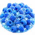 A pile of bright blue, sugar-coated raspberry-shaped candies mixed with translucent blue and clear crystals on a white background.