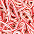 A close-up image of multiple candy cane candies, showcasing their striped red and white pattern.