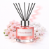 Diffuser bottle labeled 'Cherry Blossom' with black sticks on a white background
