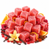 A pile of square pink-red candied sweets coated in sugar, arranged with citrus slices, cranberries, vanilla beans, cinnamon sticks, and a yellow orchid on a white background.