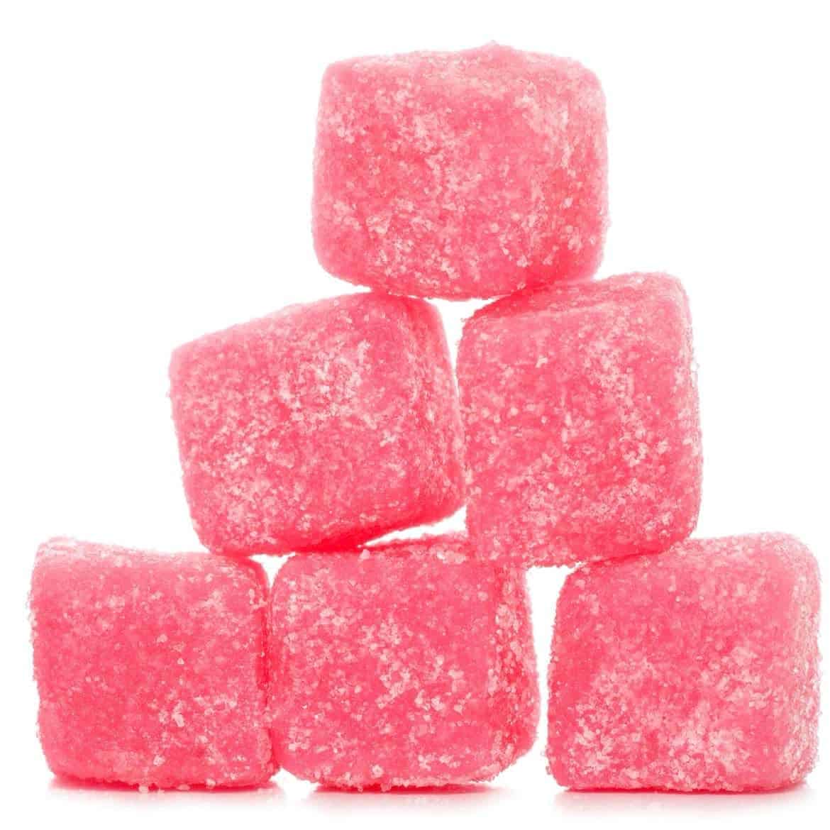 A group of pink colored sweets, cube-shaped stacked together.