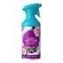 A bottle of Cosy Cottage room spray with a bright turquoise trigger sprayer and a purple label decorated with pink roses, snow, and a small cabin illustration.