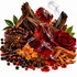 A styled arrangement of warm spices and botanicals on a white background, including amber-red translucent crystals, dark brown wood pieces, cinnamon sticks, star anise, black and red peppercorns, green leaves, and a deep red rose.
