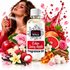 A bottle of Fizzy Whiz Eden Juicy Apple Fragrance Oil centered in a styled studio composition with a woman holding a perfume spray in the background, surrounded by red apples, pink flowers, grapefruit, berries, vanilla beans, amber crystals, and a red liquid splash on a white background.
