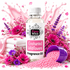A bottle of Fizzy Whiz Enchanted Wildflowers Fragrance Oil surrounded by pink and purple wildflowers, pink petals, a purple cup spilling pink beads, and folded white towels against a white background with a pink splash graphic.
