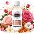 A bottle of Fizzy Whiz Fragrance Oil in the 'Fakher Rose' scent, surrounded by pink roses, cotton bolls, amber resin, and a splash of rose water on a white background.