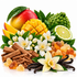 A styled arrangement of citrus and spice ingredients on a white background, including a mango, sliced mango, kumquato, lime half, white flowers, vanilla beans, cinnamon sticks, and amber gummy candies.