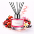 Pink diffuser bottle labeled 'Fantasy' with black sticks surrounded by fruits and flowers on a white background