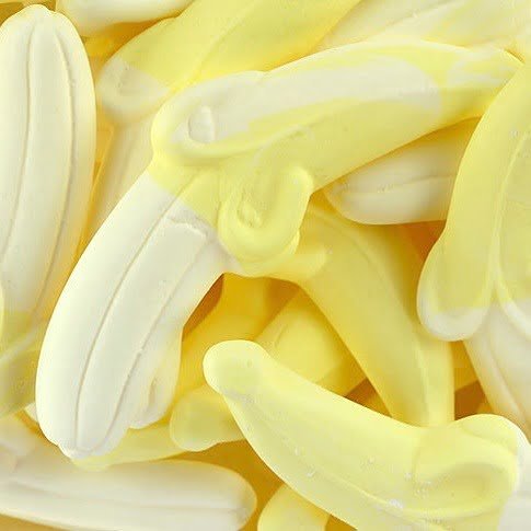 A close-up image of numerous banana-shaped candy pieces in a yellow color, associated with the fragrance oil product title.