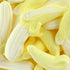 A close-up image of numerous banana-shaped candy pieces in a yellow color, associated with the fragrance oil product title.
