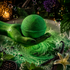 A green bath bomb held in a hand over foaming green water, surrounded by botanical elements like mint leaves, a vanilla bean, peppercorns, and bubbles in a dark, atmospheric setting.