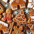 A variety of gingerbread cookies with icing and sprinkles on a wooden surface.