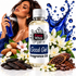 A bottle of Fizzy Whiz 'Good Girl' fragrance oil is centered in a styled product composition. A woman appears behind the bottle spraying a blue atomizer, with blue liquid splash graphics, white flowers, almonds, cocoa beans, and cocoa powder arranged around the product.