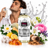 A bottle of Fizzy Whiz 'Izzy Miyaki' fragrance oil is centered in front of a man spraying perfume, surrounded by flowers, citrus, amber crystals, and scent ingredients on a white background with water splash graphics.