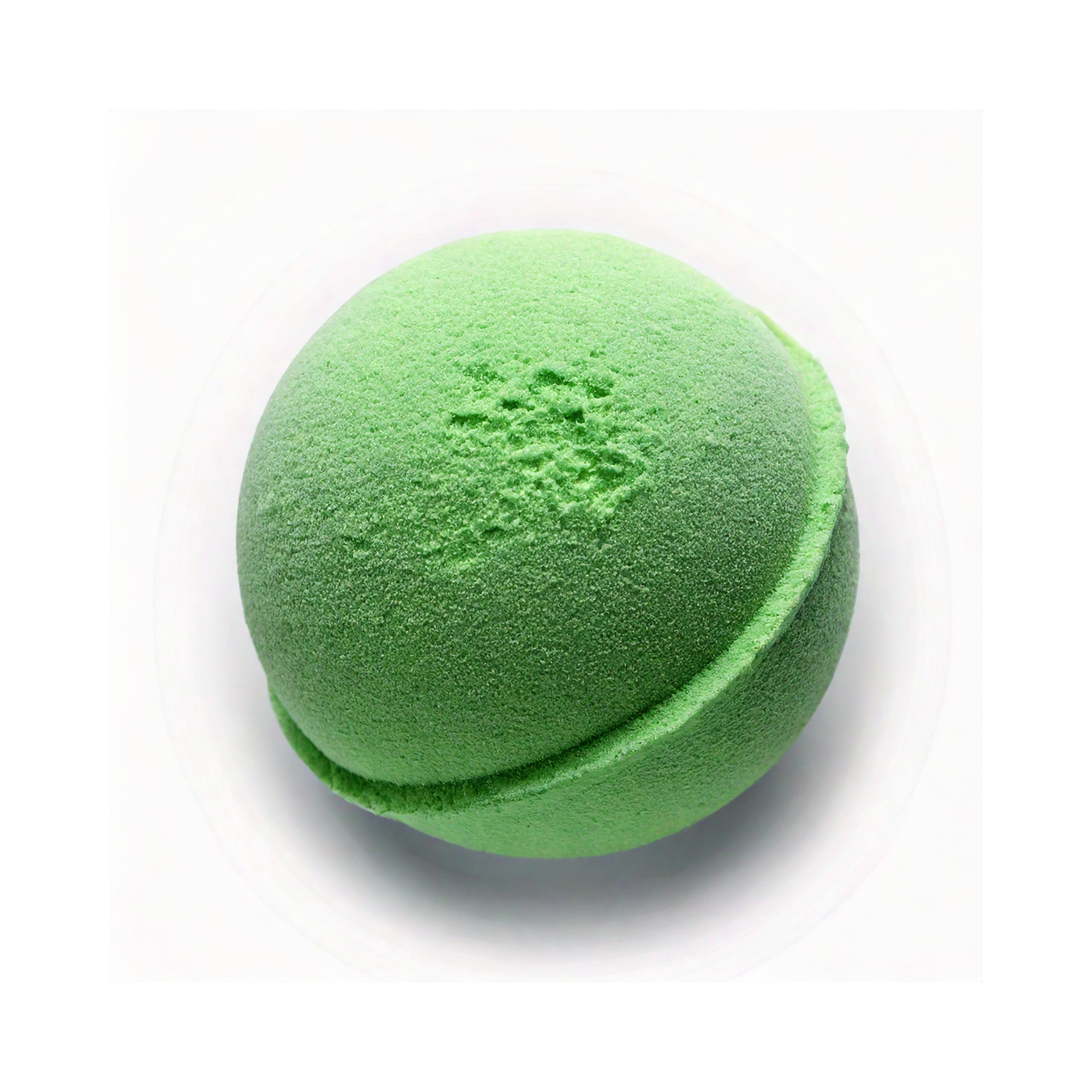 Green round bath bomb with a smooth, slightly textured surface and a central seam, shown on a light background.