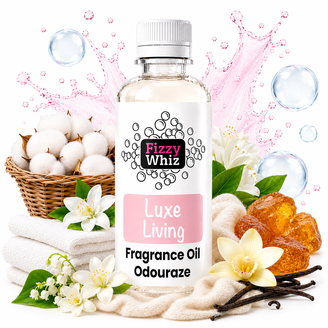 A bottle of Fizzy Whiz LuxE Living Fragrance Oil centered on a white background, surrounded by decorative props including cotton bolls in a basket, folded white towels, white flowers, amber wax melts, vanilla beans, and pink splash graphics.