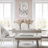 Dining room with a table, chairs, and pink flowers in a vase.