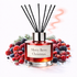 Reed diffuser labeled 'Merry Berry Christmas' surrounded by faux berries on a white background