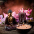 A serene setting with a statue of Buddha, lit candles, and incense sticks, surrounded by pink flowers and a bowl of Nag Champa fragrance oil.