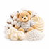A teddy bear wearing a striped shirt sits surrounded by cotton bolls, cream-colored yarn swatches, and a pile of white cotton lint on a clean white background.