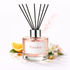 Reed diffuser labeled 'Paradox' with black sticks, lemon, and flowers on a white background