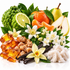 A colorful arrangement of natural ingredients and flavor elements on a white background, including amber honey, brown sugar, vanilla beans, white flowers, a green custard apple, a lime slice, an orange, a pear, and a pomegranate.