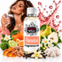 A bottle of Fizzy Whiz Paradox Fragrance Oil centered in a styled commercial composition, surrounded by citrus, pears, flowers, vanilla beans, amber pieces, and a pink liquid splash on a white background. A woman appears in the upper left holding a perfume spray bottle.
