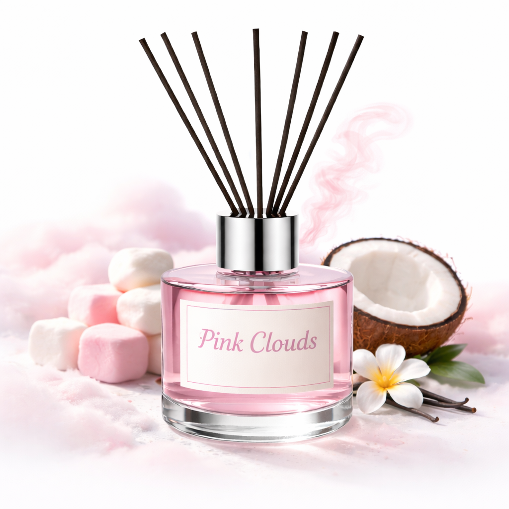 Diffuser with 'Pink Clouds' label surrounded by coconut halves, flowers, and marshmallows on a soft pink background