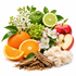 A styled arrangement of whole and sliced fruits and flowers on a white background: an orange, a red apple with a cut half, a lime half, green leaves, white blossoms, and a pile of dried bark pieces with a fluffy cream fiber mass nearby.