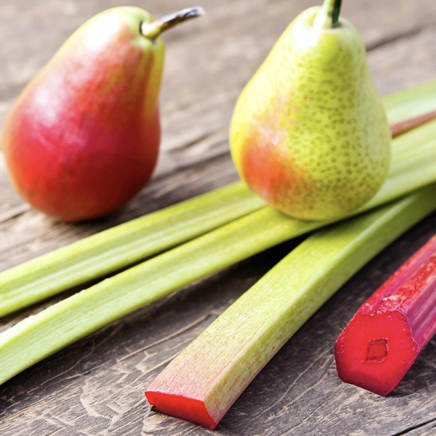 Fresh rhubarb and pears on a wooden surface, likely used for making the fragrance oil.