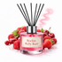 Reed diffuser labeled 'Rockin Ruby Razz' with strawberries and cherries around it on a white background