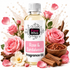 A bottle of Fizzy Whiz Rose & Sandalwood Fragrance Oil centered on a white background, surrounded by pink roses, sandalwood pieces, cinnamon sticks, and rose petals. The bottle has a white cap and a white label with pink and black text.