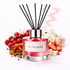 Reed diffuser labeled 'So Scandal' with fruit and floral elements on a white background