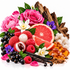 A colorful still life arrangement of natural ingredients on a white background, including pink roses, grapefruit slices, raspberries, blackcurrants, vanilla beans, amber crystals, wood pieces, and white blossoms.