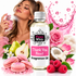 A bottle of Fizzy Whiz fragrance oil centered in the foreground, surrounded by pink roses, macarons, raspberries, pears, a coconut, and a woman holding a perfume bottle in the background. Pink graphic splashes and hearts decorate the scene.