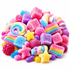 A pile of colorful, sugar-coated candies on a white background, including rainbow-striped gummy candies, pink and purple cubes, star-shaped gummies, jelly beans, and a raspberry.