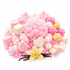 A styled assortment of pink and white sweets and confectionery ingredients arranged on a white background, including marshmallows, macarons, candy cubes, pink rhinestones, vanilla beans, and a yellow vanilla flower.