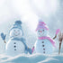 Two snowmen with hats and scarves in a snowy landscape, representing the 'White Christmas Fragrance Oil' intended for seasonal home fragrance.