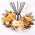 Reed diffuser labeled 'Winter Spice' with decorative elements like oranges, cinnamon sticks, and pine cones on a light background.