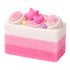 Pink and white layered soap with decorative elements on a white background